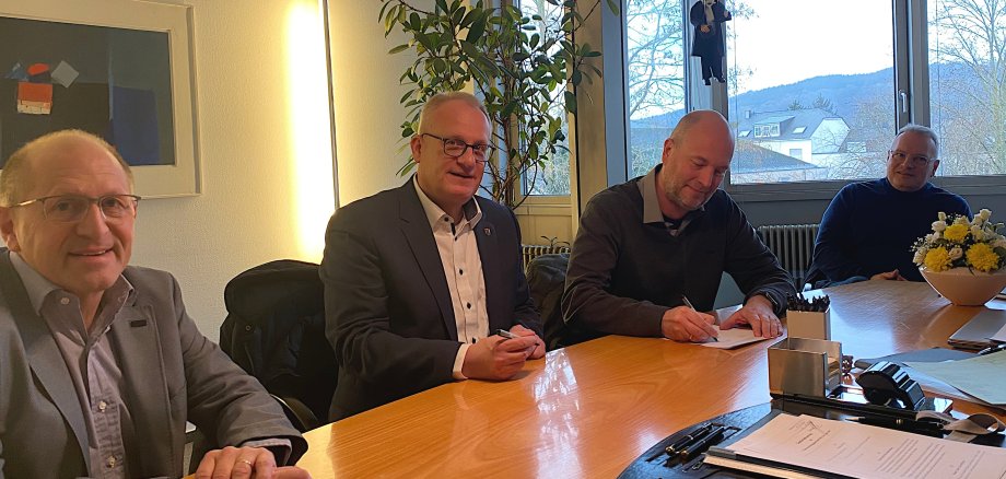 Bürgermeister Holstein (2.v.l.) und Christian Reinert (2.v.r.) unterzeichnen im Beisein von Arndt Müller, Vorstand der SWT AöR (r.), und Matthias Wagner (l.), der für die Verbandsgemeinde in der Geschäftsführung der PEG tätig sein wird, den Gesellschaftsvertrag vor Notar Dempfle